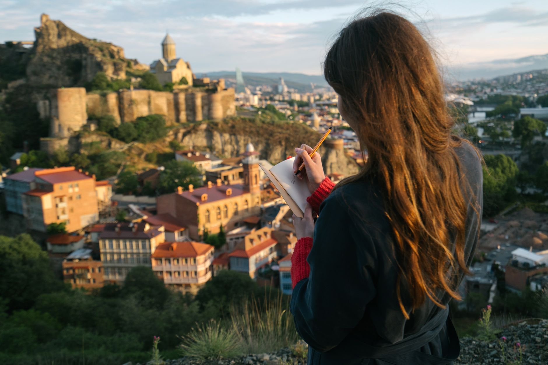 Journalist writing notes in outdoor field sketchbook